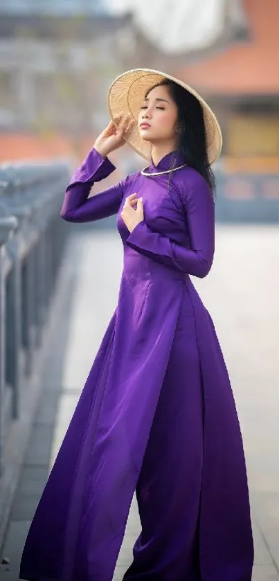 Elegant woman in purple dress with traditional hat on a serene bridge.