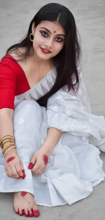 Woman in red blouse and white saree, cultural elegance.