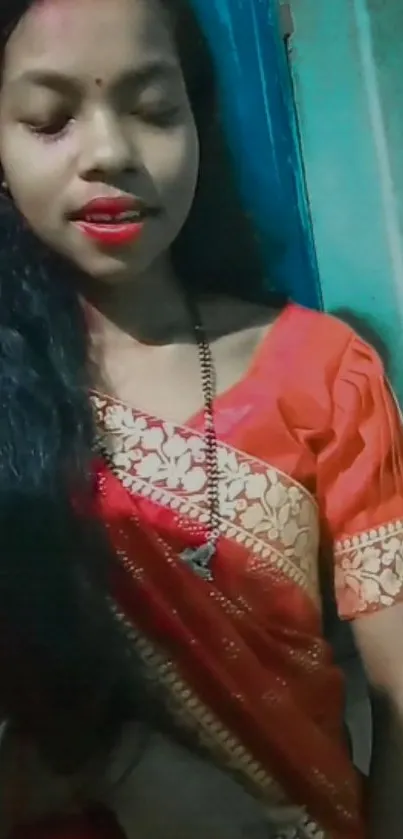 Woman in red saree with elegant styling and cultural attire.