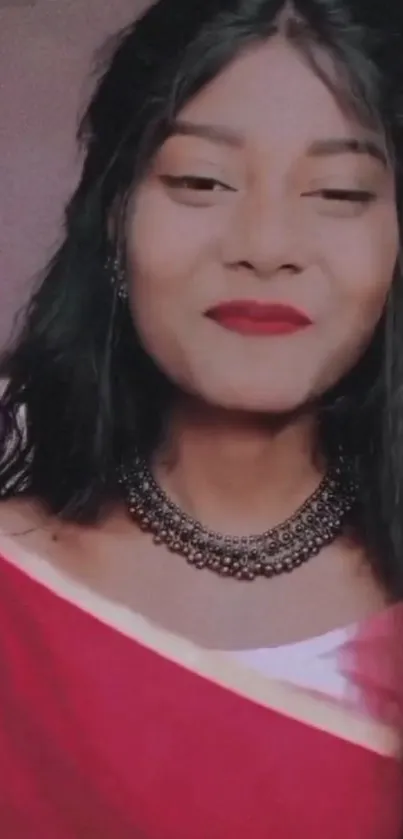 Elegant woman in a red saree smiling gracefully.