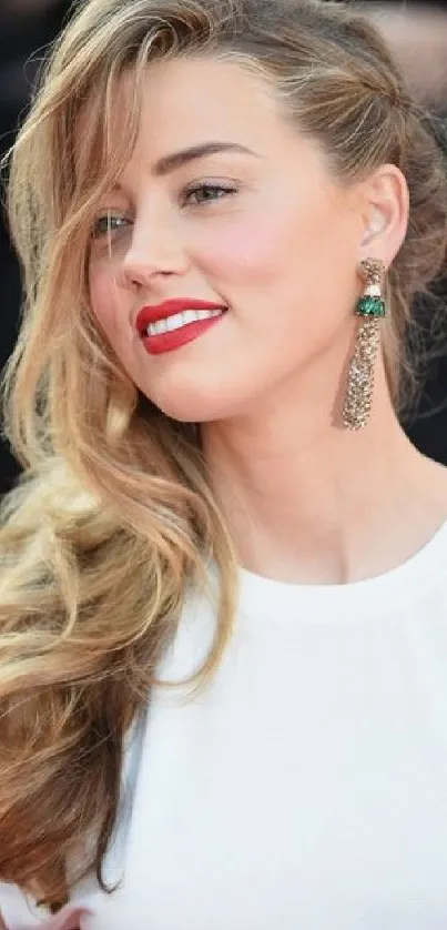 Woman with blonde hair and white tee, wearing earrings.