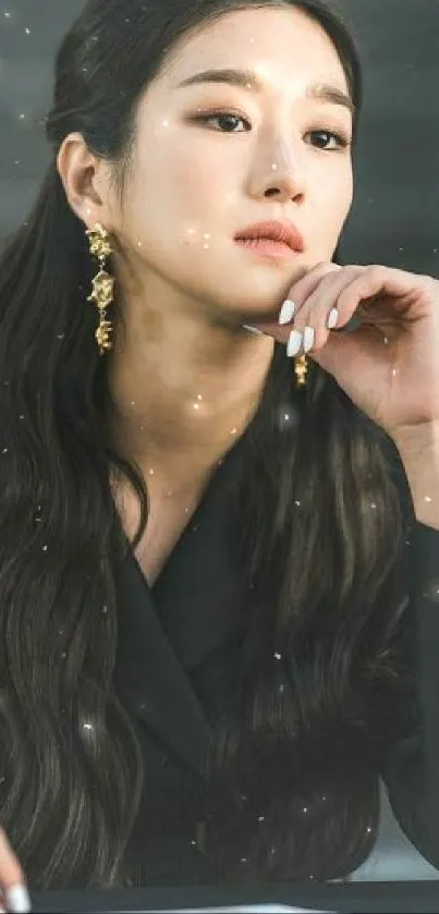 Elegant woman with long dark hair and gold earrings in a portrait.