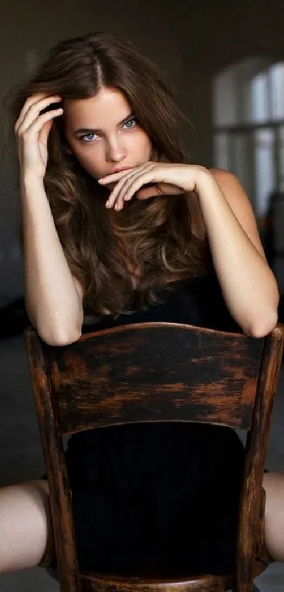 Stylish woman sitting on a chair in dark ambiance.