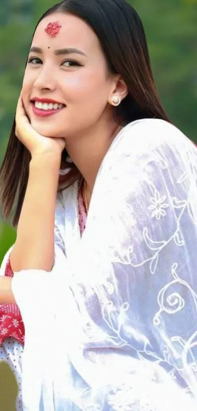 Elegant woman smiling in white floral attire with green background.