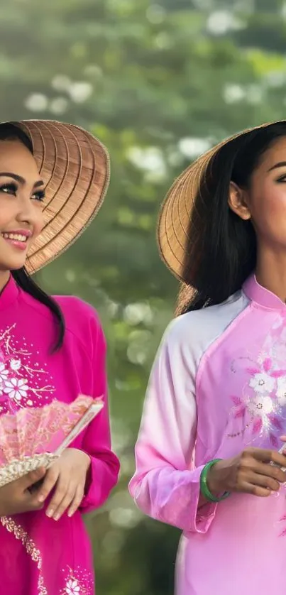 Two women in pink traditional dress smiling outdoors.