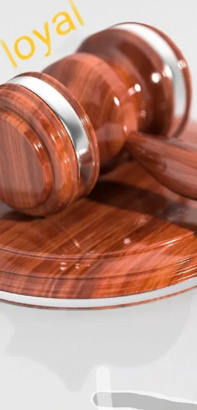 Wooden gavel on reflective surface with 'loyal' text.