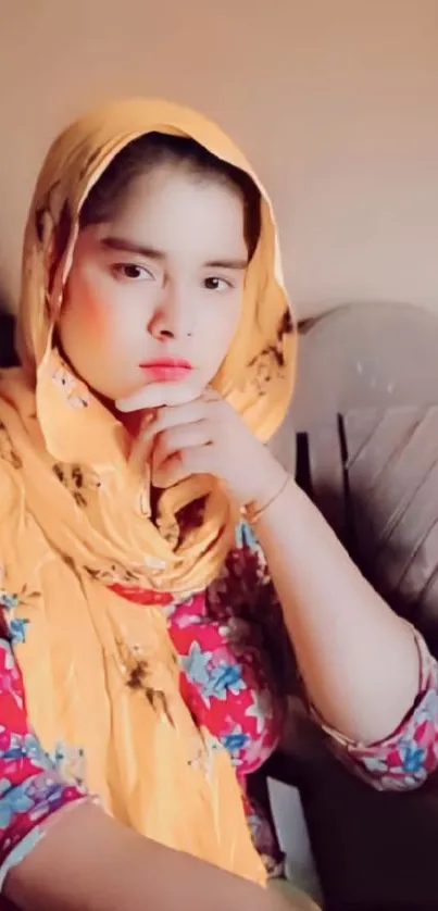 Portrait of a woman in a yellow headscarf with colorful attire and a thoughtful pose.