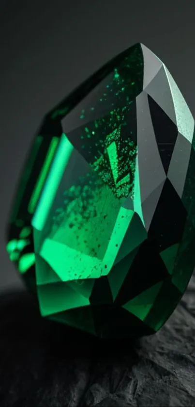 Emerald gemstone resting on a textured rock surface.