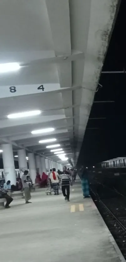 Quiet railway station platform at night.