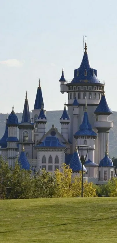 Enchanting fairytale castle with blue spires and green landscape.