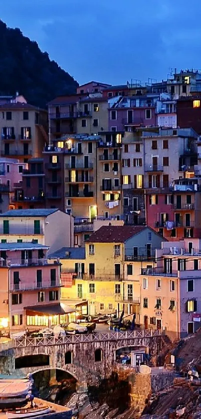 Beautiful coastal cliffside town at night with illuminated buildings and ocean view.