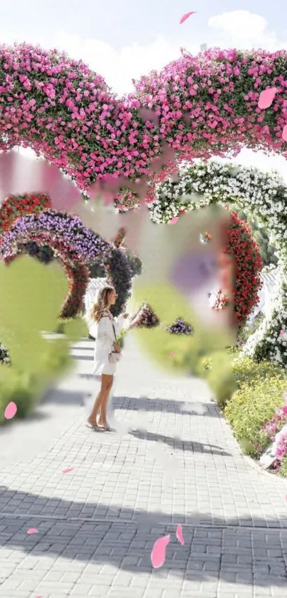 A woman stands under floral heart arches in a romantic garden setting.