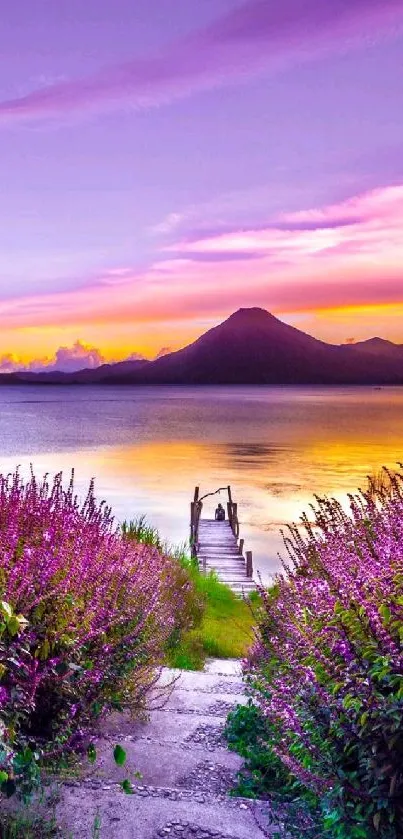 Purple sunset over lake with mountains and walking path.