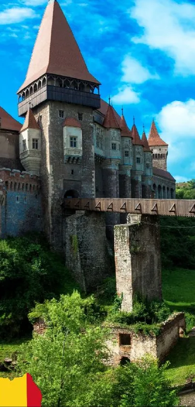 Hunedoara Castle under vibrant blue sky with lush greenery in Romania.