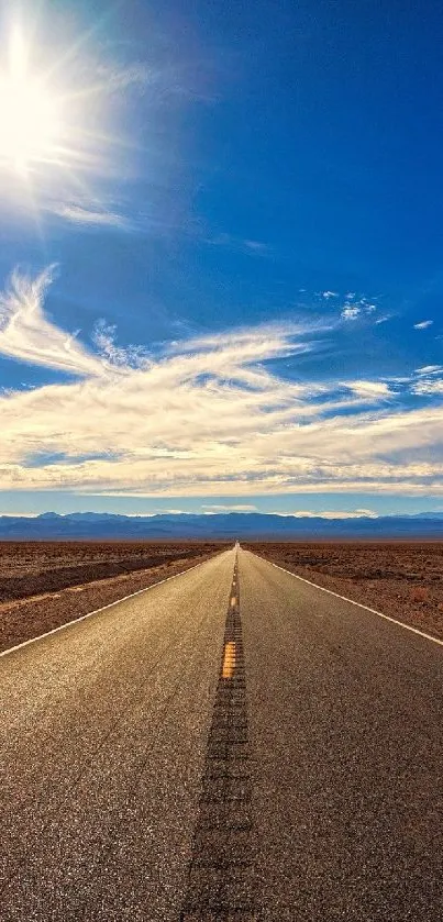 A mesmerizing desert road under a bright blue sky with the sun overhead.