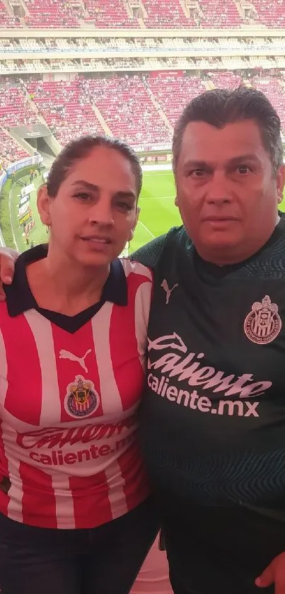 Fans in jerseys at a vibrant football stadium.