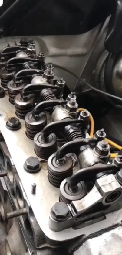 Close-up image of engine rocker arms on a metal surface.