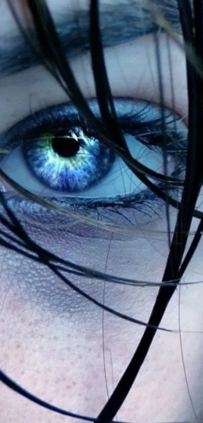 Close-up of a mysterious blue eye with dark hair strands.