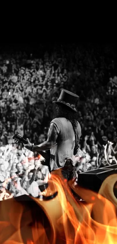 A guitarist performs on stage in front of a lively crowd in black and white.