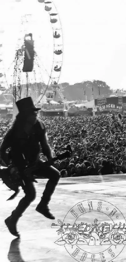 Silhouetted guitarist at a live music festival with Ferris wheel in the background.