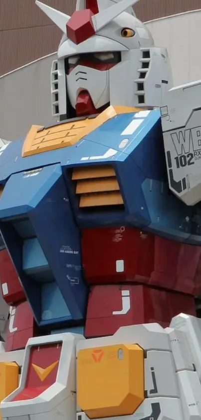 Gundam statue with colorful panels on a museum facade.