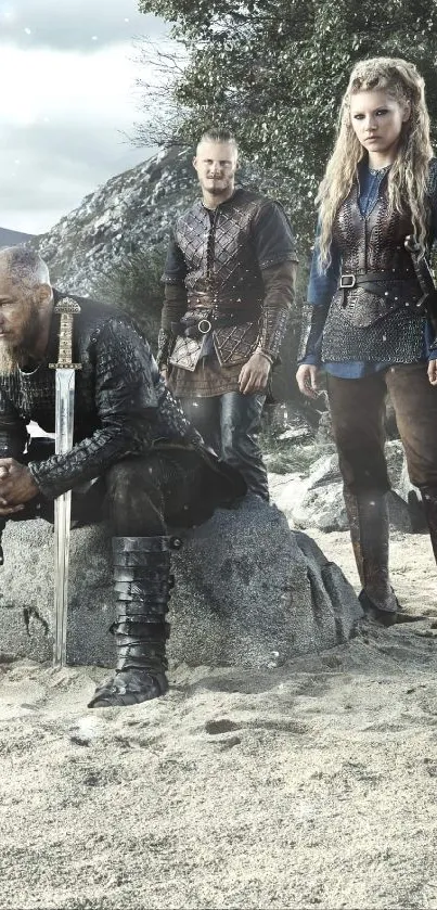 Three medieval warriors on a sandy beach with mountains.