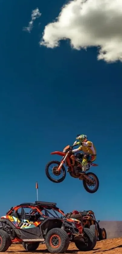 Biker jumps over buggy in desert landscape under blue sky.