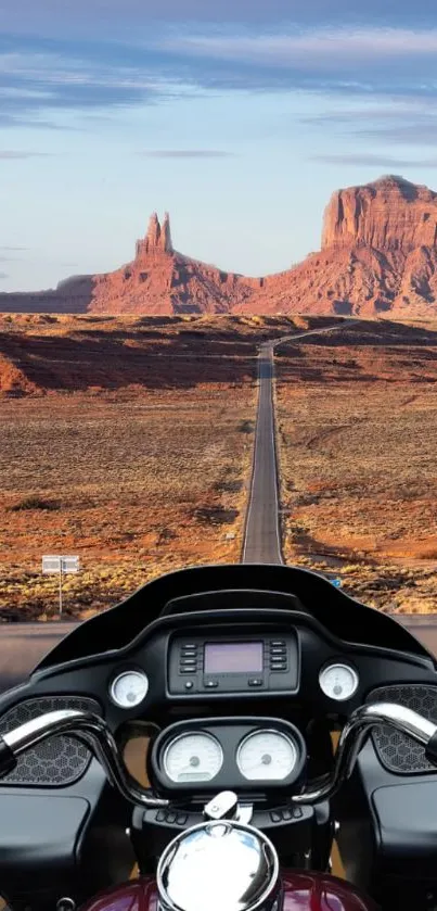 Motorcycle on scenic desert road with a breathtaking view of red rock formations.