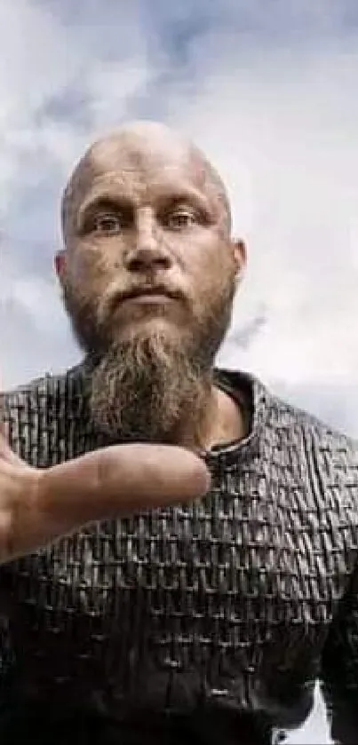 Bearded warrior holding a cross with sky background.