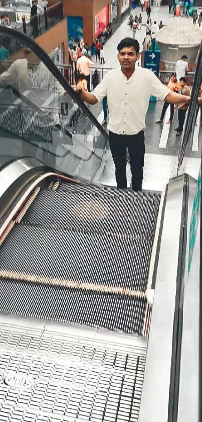 Man standing on an escalator in a bustling shopping mall.