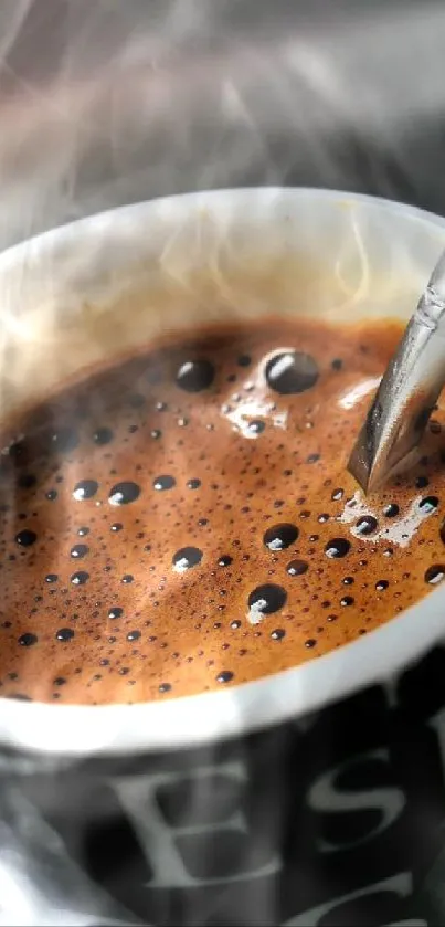 Espresso coffee in a black cup with a spoon on a reflective surface.