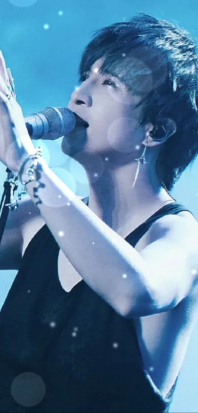 Singer performing with blue lighting in a concert wallpaper.