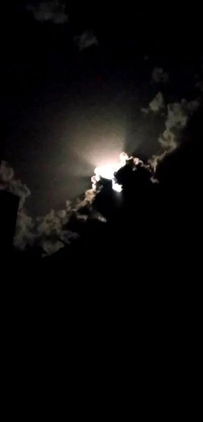 Moonlit cloud silhouette against night sky.