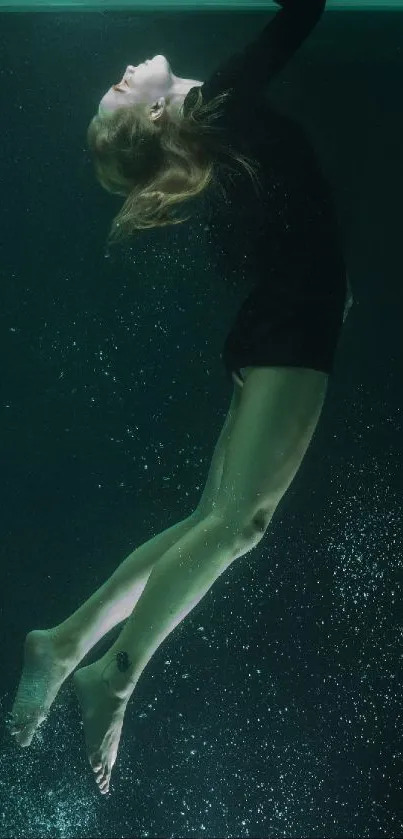 Graceful underwater woman in dark green setting.