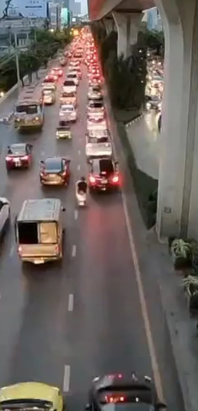 Evening city traffic under an overpass with colorful headlights and urban scenery.