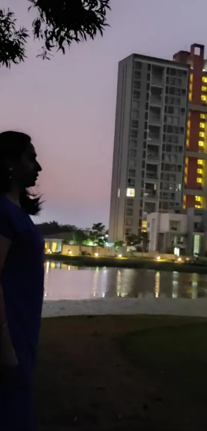 Silhouette against a cityscape at dusk with reflections on a lake.