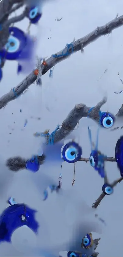 Blue evil eye charms on branches in wallpaper.