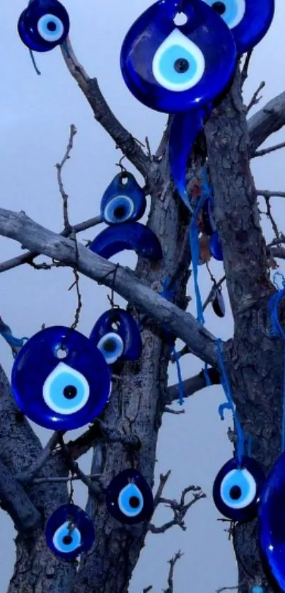 Blue evil eye charms hanging from a tree on a wallpaper.