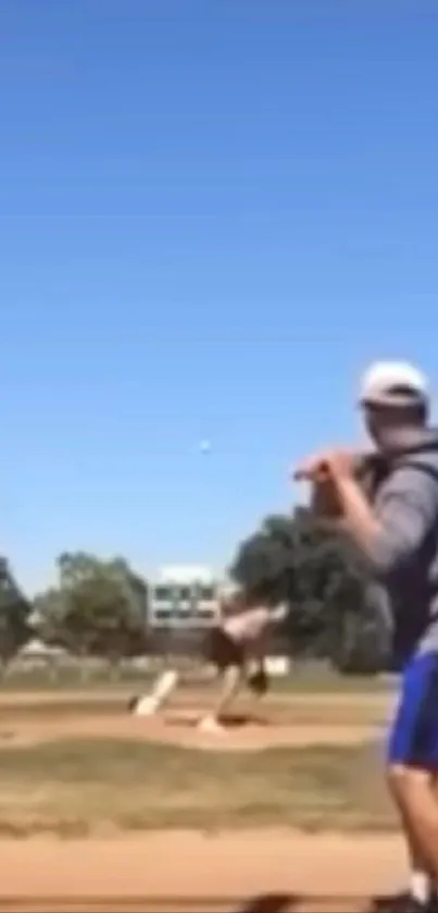 Baseball player ready to bat under a clear blue sky.