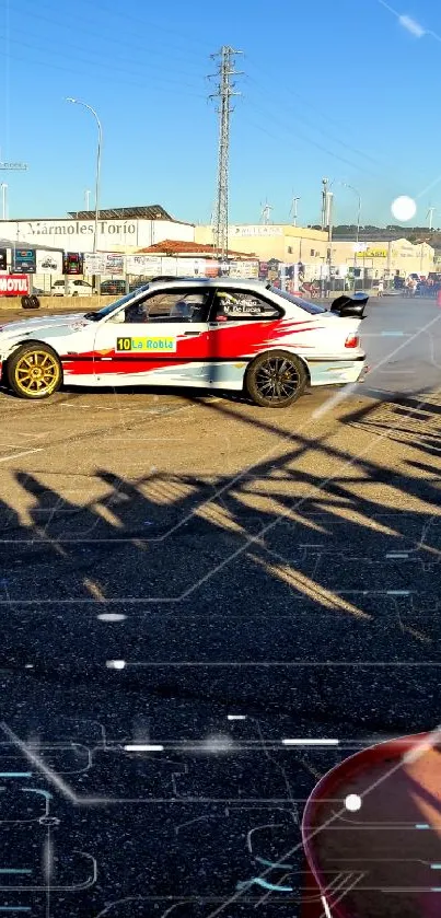 Action-packed car drift scene with shadows on a racetrack during the day.