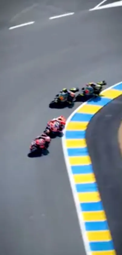 Motorcycles race around a colorful track bend.