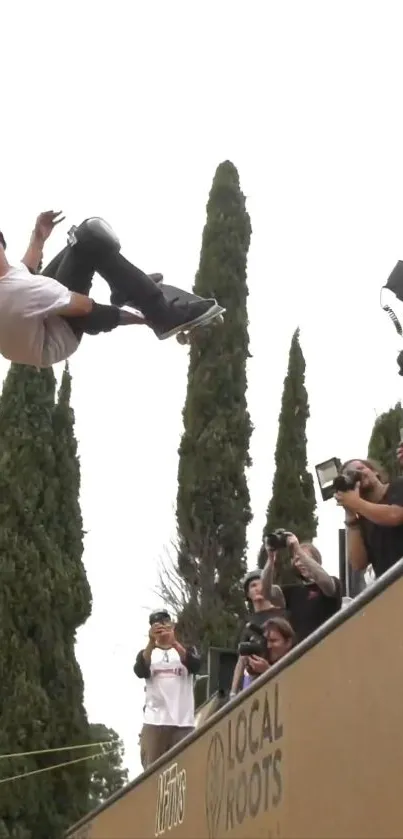 Skater performing high-flying trick surrounded by photographers.