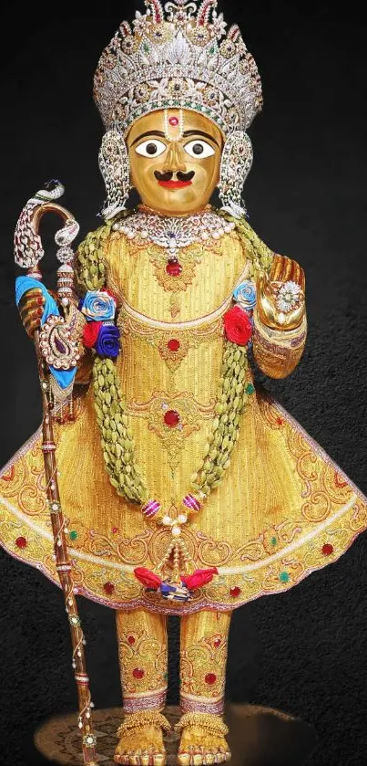 Golden deity adorned with jewels and intricate details on a dark background.