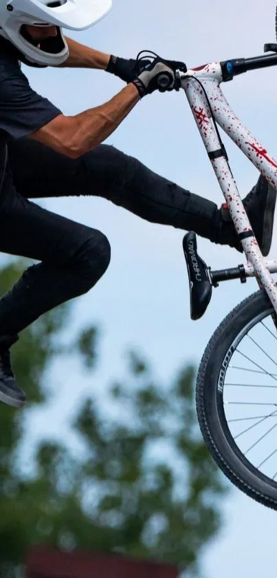 BMX rider performing an intense mid-air stunt against a clear blue sky.