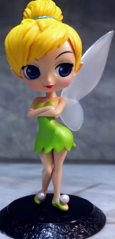 Charming fairy figurine with green dress and wings on a decorative stand.