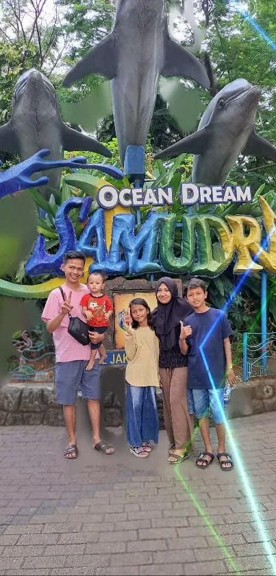 Family poses at Ocean Dream Jakarta with dolphin statues.
