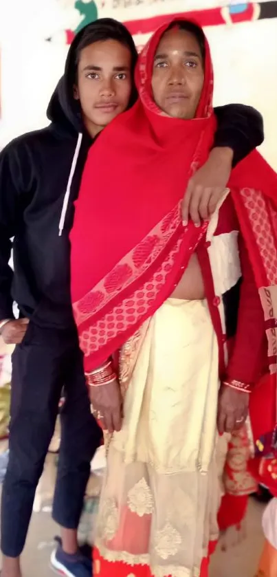 Mother and son embracing in vibrant red attire.