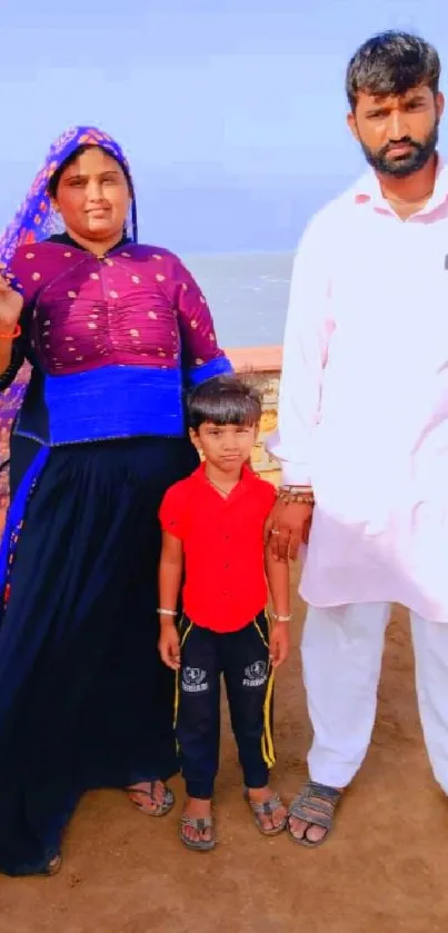 Family posing by the beach with vibrant colors and a serene ocean background.