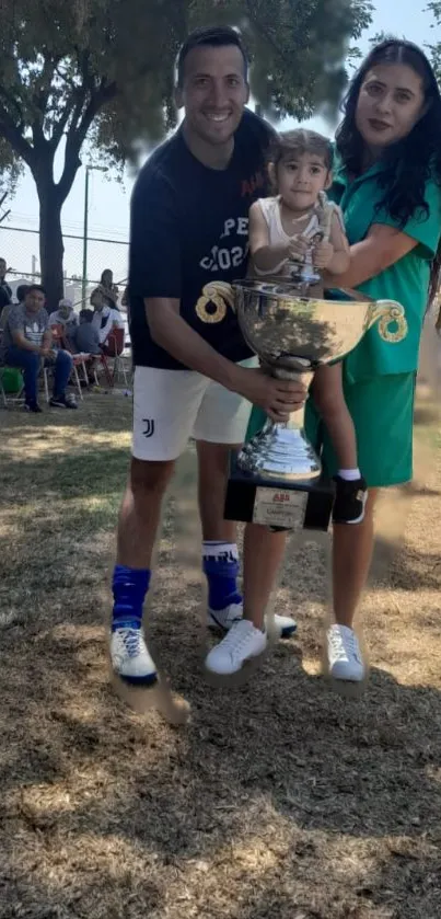 Family joyfully holding a large trophy outdoors.