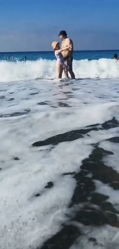 Family enjoying the beach with waves and blue sky.